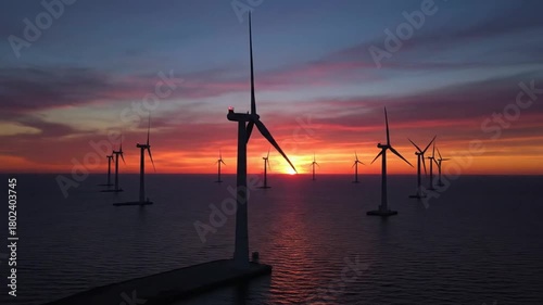 Offshore wind turbines in the sea at sunset renewable energy concept blades rotating power generation