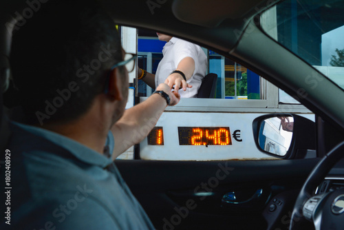 A man pays money to a cashier for a toll road