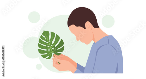 Profile view of a person gently holding and carefully examining the details of a fresh green monstera deliciosa leaf.