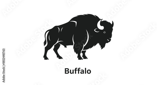 A striking black silhouette of a majestic bison stands powerfully