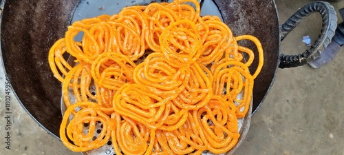 Jalebi is a Pakistani dessert. Sweet with sugar syrup fried in oil or ghee. Fresh batch of Jalebi. Crispy Jalebi.(traditional Pakistani sweet dessert). Pakistani jalebis arranged for sale. 4K Footage.