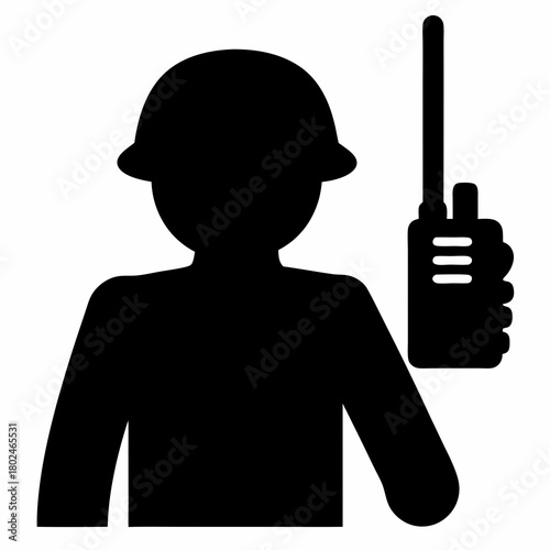 Silhouette of a worker wearing hardhat holding walkie talkie communication device