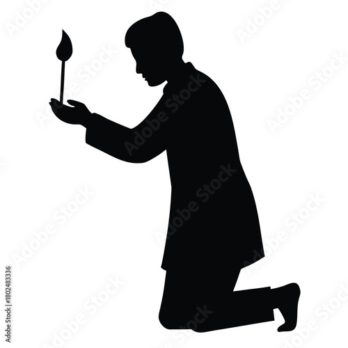 Silhouette man kneeling holding flame representing spiritual belief faith
