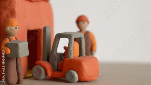 Mini clay forklift and worker figures in distribution warehouse scene showing teamwork and logistics concept