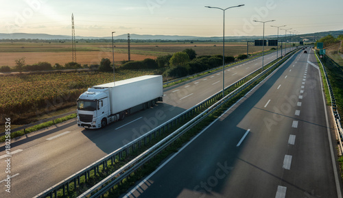 Transportation truck with semi-trailer driving along highway on the sunset background. Services and Transport logistics. Modern Lorry Transport concept. Long Self-driving lorries