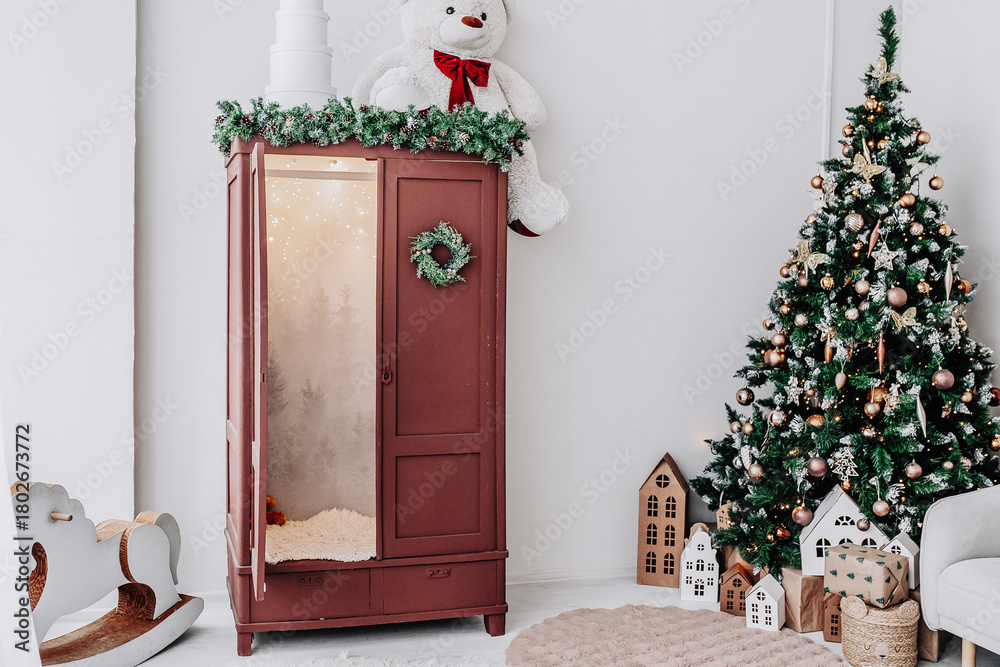 Fototapeta premium New year interior, children's room, Christmas tree, wardrobe decorated with fir branches. Selective focus. Perfect for promoting holiday home decor