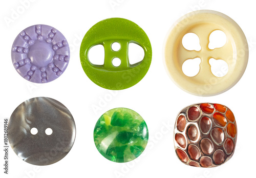 Isolated photo of various colored vintage glass and plastic cloth buttons on white background.