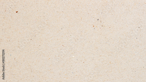 Macro of beige recycled craft paper with natural fiber and small colorful inclusions. Natural background for eco design, packaging or sustainable texture, copy space