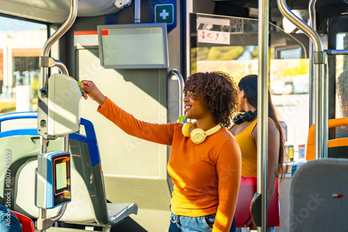 Young woman paying bus fare using validator