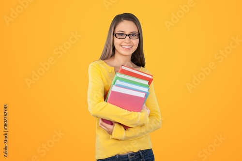 Positive young woman student with notebooks posing