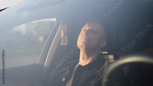 A tired passenger relaxes while sitting in a comfortable car
