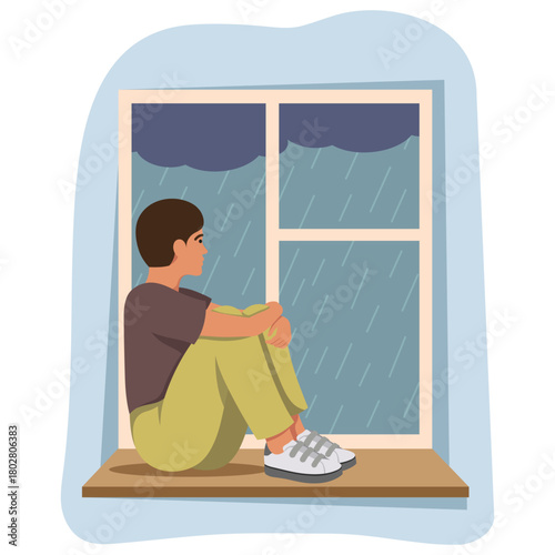 A boy sits with knees to chest by a window watching rain fall outside, flat style, on a white background. Concept of sadness and loneliness. Vector illustration