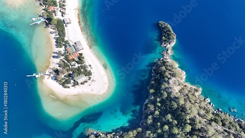 Fototapeta Naklejka Na Ścianę i Meble -  A drone view of the Ölüdeniz peninsula and its turquoise lagoon on the Mediterranean coast of Turkey, surrounded by forested mountains and clear blue water.
