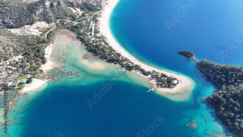 Fototapeta Naklejka Na Ścianę i Meble -  A drone view of the Ölüdeniz peninsula and its turquoise lagoon on the Mediterranean coast of Turkey, surrounded by forested mountains and clear blue water.