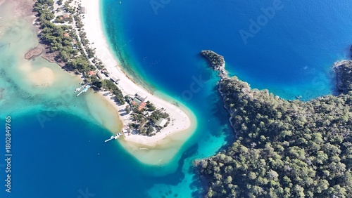 Fototapeta Naklejka Na Ścianę i Meble -  A drone view of the Ölüdeniz peninsula and its turquoise lagoon on the Mediterranean coast of Turkey, surrounded by forested mountains and clear blue water.