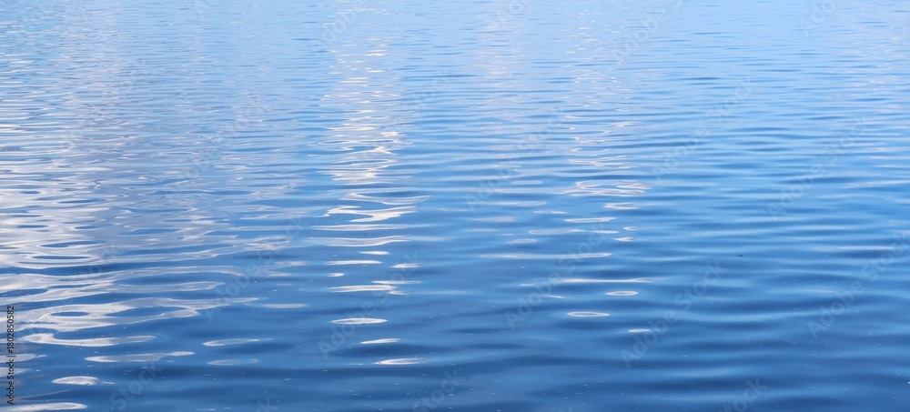 Naklejka premium Light blue smooth and shiny water surface, natural background