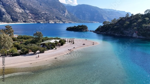 Fototapeta Naklejka Na Ścianę i Meble -  A drone view of the Ölüdeniz peninsula and its turquoise lagoon on the Mediterranean coast of Turkey, surrounded by forested mountains and clear blue water.