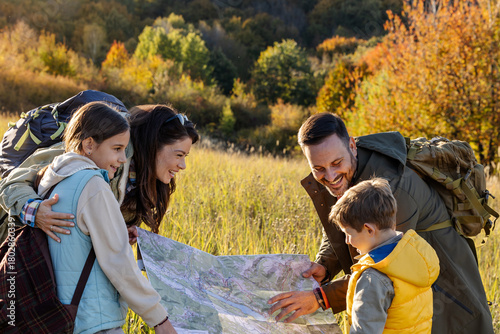 Family reading a map in a grassy field
