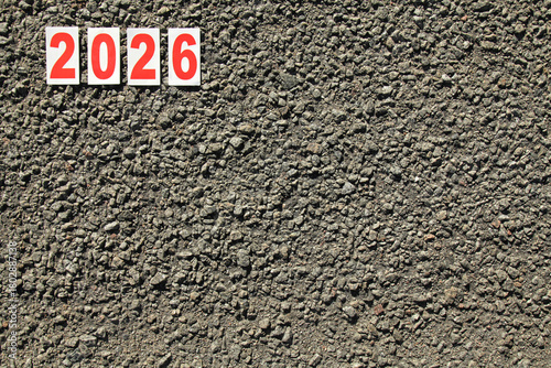 Numbers of 2026 year. Paper square numbers on the stone road background, that means coming New Year Eve. Christmas, holidays, celebration concept. New Year of 2026, year of the red fire horse