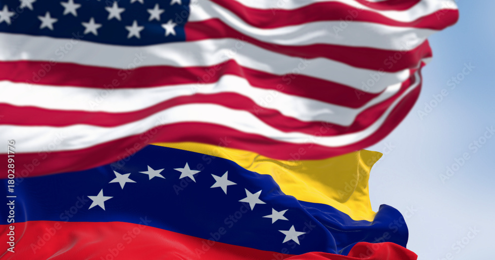 Obraz premium Venezuela and US national flags waving in the wind on a clear day