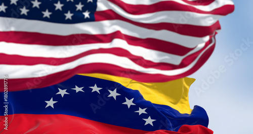 Venezuela and US national flags waving in the wind on a clear day