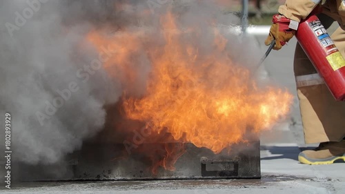 Firefighter extinguishing open flame with extinguisher during training