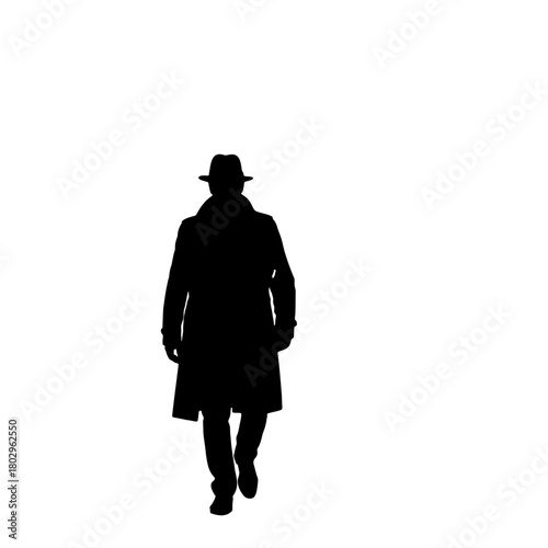 A silhouette of a man wearing a hat and a long coat walking forward on a white background in a studio shot
