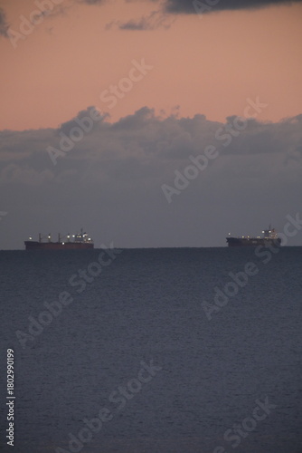 Two huge shipping boats are waiting to enter the Saint-Nazaire harbor. Le Pouliguen, France - November 17, 2025.