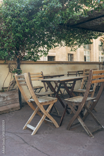 Empty cafe patio with wooden tables and chairs