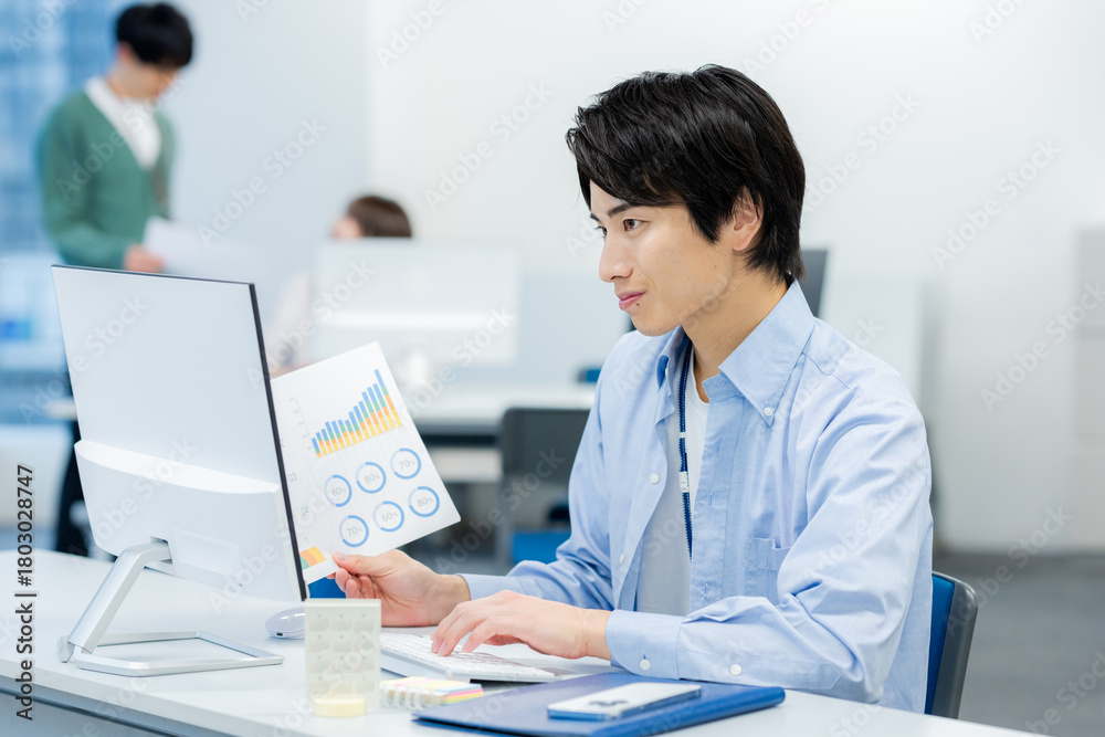 Fototapeta premium オフィスで働く若いビジネスマン