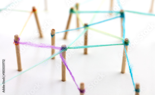 Linking entities. Networking, social media, SNS, internet communication abstract. devices or people connected to a network. Web of green, blue and purple wires on white background. Shallow DOF.