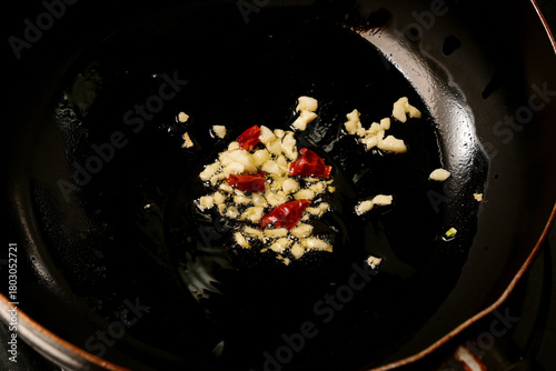 ニンニクと唐辛子をオリーブオイルで炒める様子