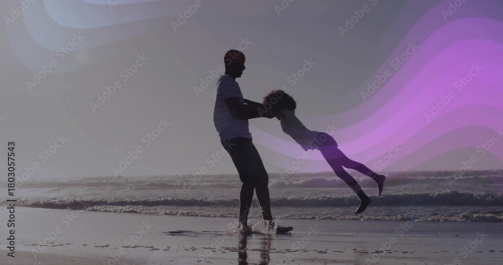 Naklejka premium Swinging father holding daughter by hands at ocean shoreline, striped shirt, purple wave overlays