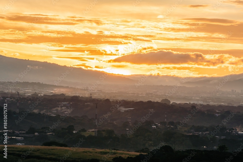 Fototapeta premium Beautiful dawn light illuminates the landscape with vibrant colors and a clear sky over the hills