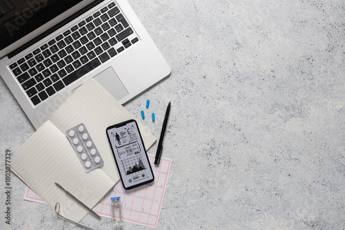 Mobile phone with laptop and medical supplies on grunge background. Telemedic...