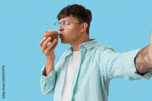 Young man with tasty muffin...