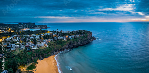 Aerial Sunrise Panorama at the Seaside with rain clouds, houses and headland views