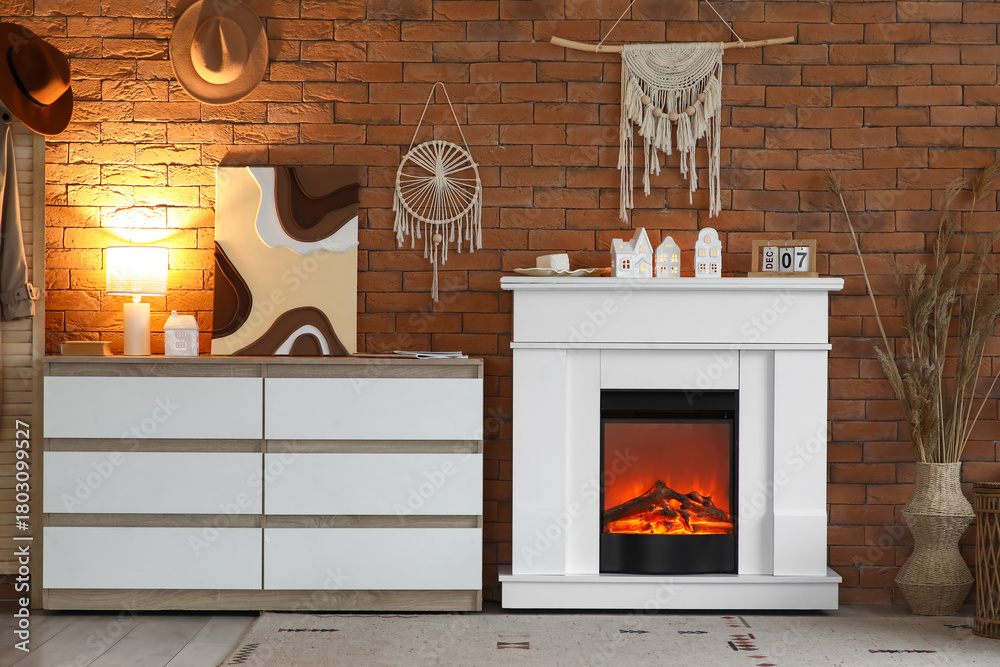 Naklejka premium Interior of stylish modern living room with fireplace and commode near brick wall
