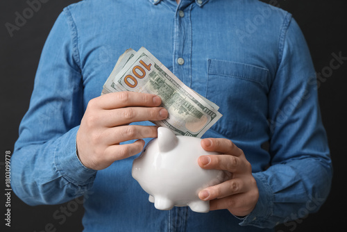 Man with money and piggy ba...
