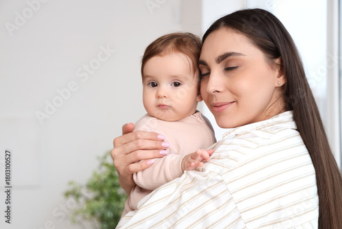 Young mother hugging her ba...