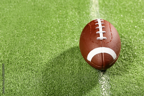 American football ball on g...