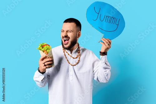 Young Muslim man holding sp...