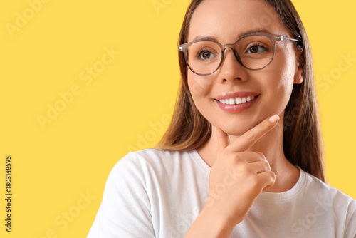 Dreamy young woman on yello...