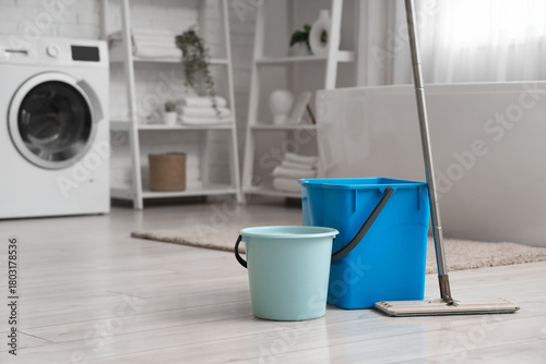 Mop with buckets on floor i...