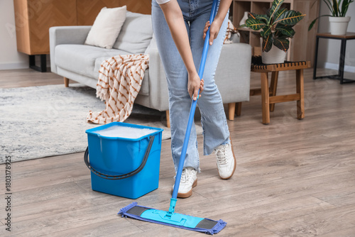 Young woman mopping floor i...