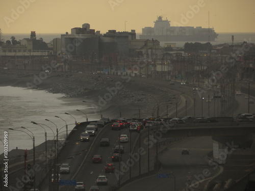 Vista hacia el puerto de El Callao y la parte final de la autopista Costa Verde. Foto al atardecer. Perú.