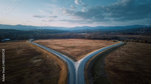 divergence. A symbolic fork in the road with two diverging paths under a dramatic sky, representing choices. wellbeing guides, coaching materials, designed for coaching and self-improvement content.