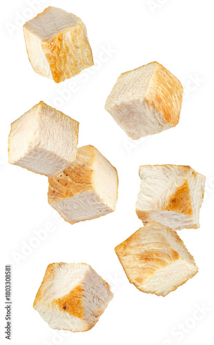 Canvas Print clean photograph of falling, cubed pieces of cooked chicken breast with light golden searing isolated on a transparent background