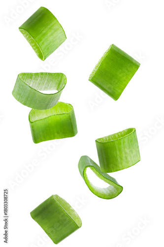 dynamic photograph of freshly sliced green onion rings falling or floating in mid-air against a plain transparent background.
