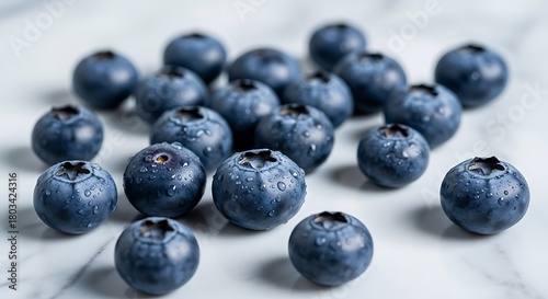 Fresh blueberries scattered on a white surface